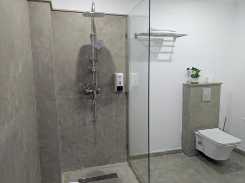 a shower stall in a bathroom with a toilet at Hôtel Les Remparts in Azemmour