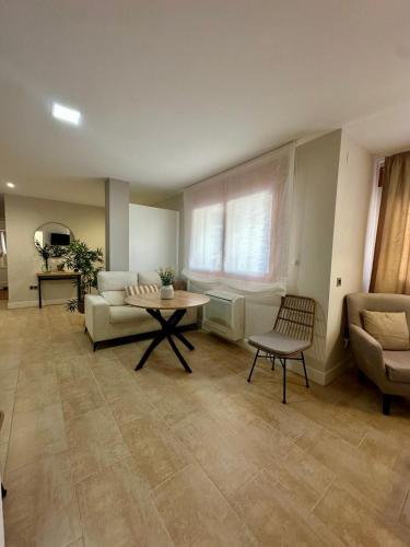 a living room with a couch and a table at Apartamentos Puente Romano Suites Parking Gratis in Merida