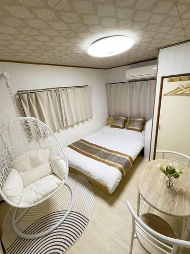 a small room with a bed and chairs and a table at 新宿后花园 in Tokyo