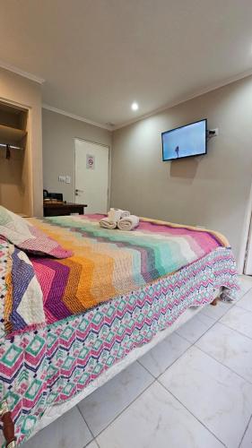 a bedroom with a bed with a colorful blanket on it at Hotel Firenze in Necochea