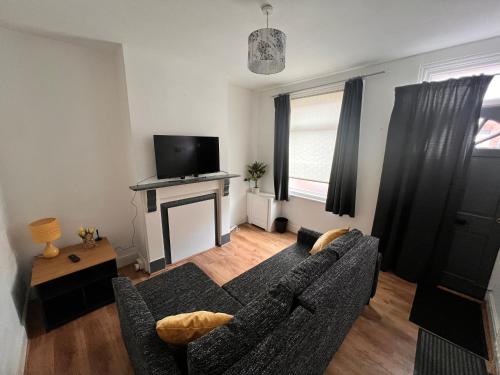 a living room with a couch and a fireplace at Visit Luton With This 2 BR Rental - Sleeps 6 in Luton