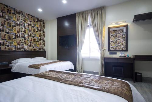 una camera d'albergo con due letti e una finestra di Island Guesthouse - Previously known as Islander Lodge a George Town