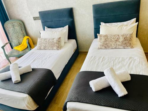 two beds in a room with towels on them at Appartement bord de mer Agadir in Agadir