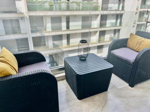 two chairs and a table in a room with a window at Appartement bord de mer Agadir in Agadir
