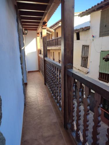 a balcony of a house with a wooden railing at Casa Rogelio Valverde in Valverde de la Vera