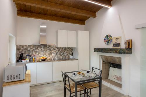 a kitchen with a table and a fireplace at Casal La Ponderosa in SantʼElpidio a Mare