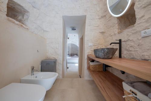 a bathroom with a sink and a tub and a toilet at Trulli DaMì in Ceglie Messapica
