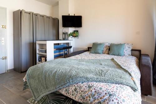 La plage Wifi Climatisation Terrasse Parking Proche mer et commerces في فالراس بلاج: غرفة نوم بها سرير وتلفزيون على الحائط