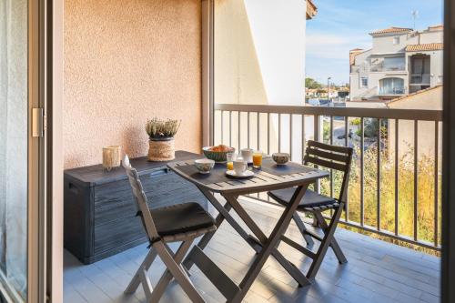 La plage Wifi Climatisation Terrasse Parking Proche mer et commerces في فالراس بلاج: طاولة خشبية وكرسيين على شرفة