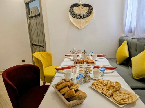 a table with bread and pastries on it at Hôtel Les Remparts in Azemmour