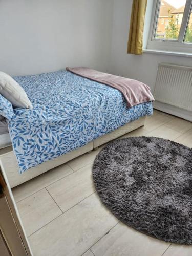 a bedroom with a bed and a rug on the floor at Idyllic Cottage in Garforth