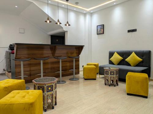 a living room with a piano and yellow furniture at Hôtel Les Remparts in Azemmour