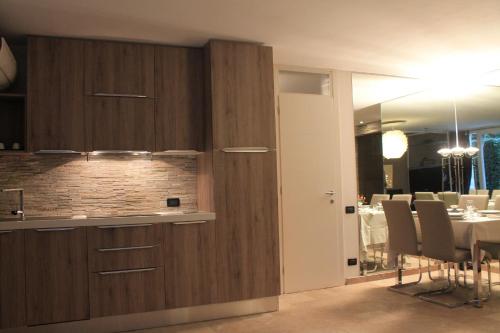 a kitchen with wooden cabinets and a dining room at Jane's Dream Apartment in San Felice del Benaco