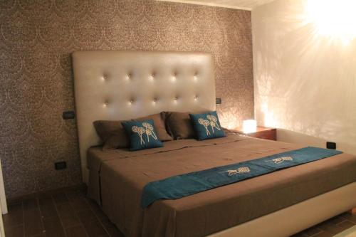a bedroom with a large bed with blue pillows at Jane's Dream Apartment in San Felice del Benaco