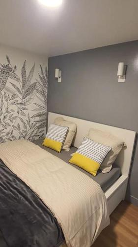 - une chambre avec un lit et 2 oreillers jaunes dans l'établissement Charmant nid au cœur de Paris, à Paris