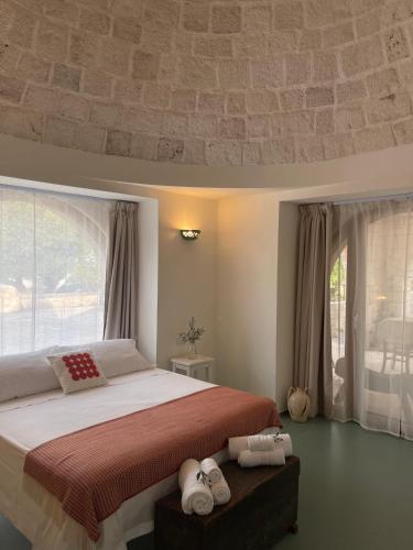 a bedroom with a large bed and a large window at Trulli Milena in Putignano