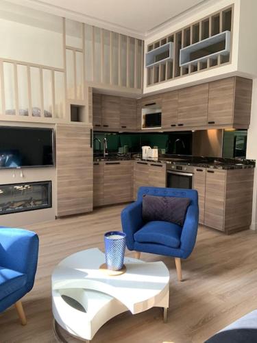 un salon avec deux chaises bleues et une table dans l'établissement Riviera Sky, appartement design centre Croisette, à Cannes