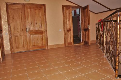 a hallway with wooden doors and a tiled floor at Troyanda in Radyvyliv