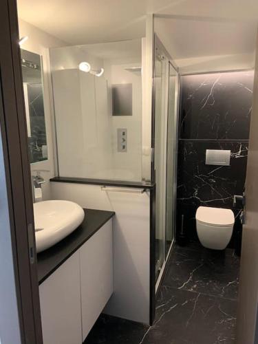 une salle de bain blanche avec un lavabo et des toilettes dans l'établissement Riviera Sky, appartement design centre Croisette, à Cannes