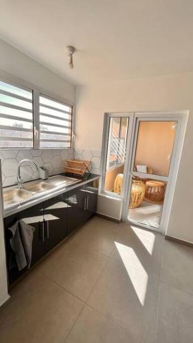 a kitchen with a refrigerator and a sink at SunSet Appart' in Saint-Pierre