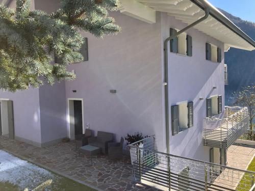 a white building with a staircase next to it at Maison Doél in Ragoli