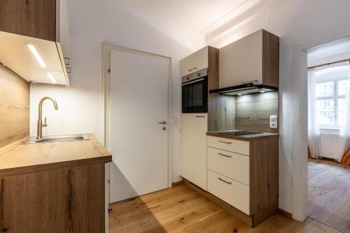 a kitchen with white cabinets and a sink at Apartments am Schloss Mühldorf in Feldkirchen an der Donau