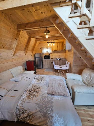 a living room with a large bed in a log cabin at Wilderness Cabin in Kolašin