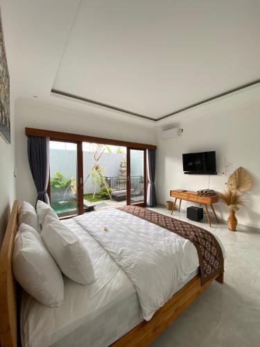 a bedroom with a large bed with a large window at Villa Made Ubud in Ubud