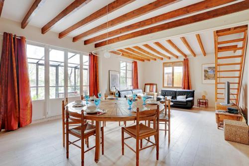 un salon avec une table et des chaises en bois dans l'établissement Le Bellevue - Maison 6 pers - Jardin - Disney, à Le Plessis-Trévise