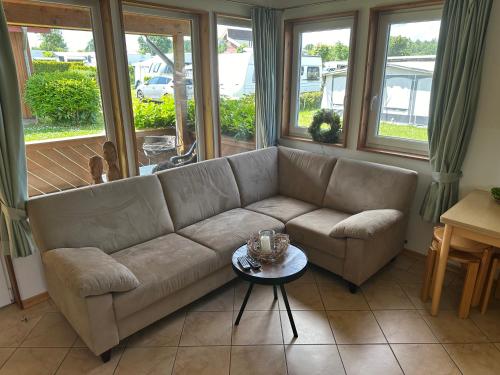 BehrensdorfにあるFerienhaus 2 Campingpark Waldesruhのソファとテーブルのあるリビングルーム