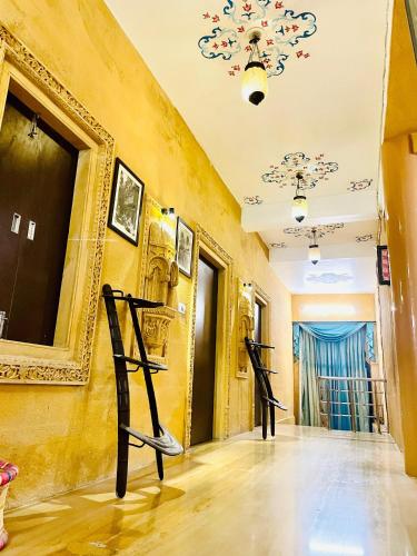 a hallway with paintings on the wall and two black sculptures at Hotel Tokyo Palace in Jaisalmer