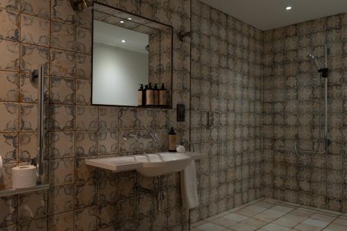 a bathroom with a sink and a mirror at Bushmills Townhouse in Bushmills