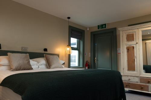 a bedroom with a large bed with a green blanket at Bushmills Townhouse in Bushmills