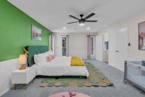 a bedroom with a bed and a green wall at Wes Anderson-Theme 5BD - Movie Theater & PingPong in Tulsa