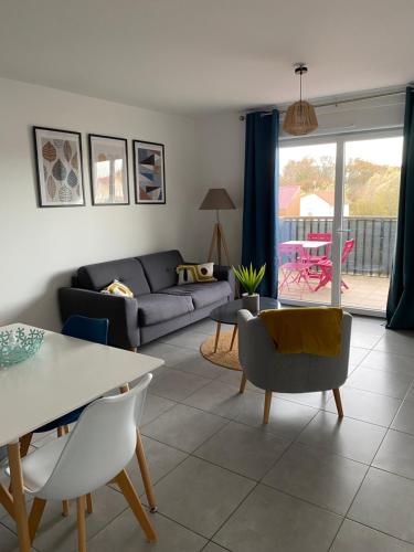 un salon avec un canapé et une table dans l'établissement Appartement NEUF à St jean de Niost tout confort, à Saint-Jean-de Niost