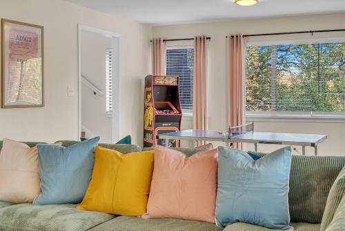 a living room with a couch with colorful pillows at Wes Anderson-Theme 5BD - Movie Theater & PingPong in Tulsa