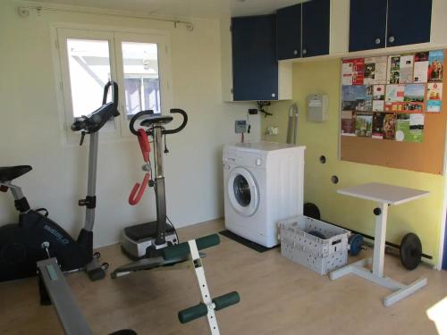 a room with a gym with a washing machine at Maison charmante avec jardin à Châteauneuf-de-Galaure in Châteauneuf-de-Galaure