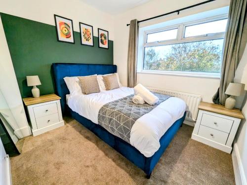 a bedroom with a blue bed and a window at Spacious 3 BDRM with Driveway , Garden, Blyth in Blythe