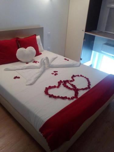 a bed with two hearts decorations on it at Apart FL in Mirandela