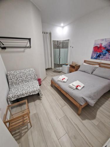 a bedroom with a bed and a chair at Il Daviduccio Suite in Siracusa