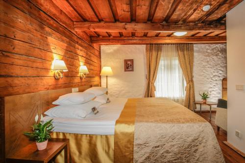 - une chambre avec un grand lit et des murs en bois dans l'établissement Vihula Manor Country Club & Spa, à Vihula