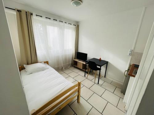 une chambre avec un lit et un bureau avec un ordinateur dans l'établissement Banyo, Studio 1p proche centre ville, à Caen