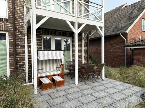 a pavilion with a table and chairs on a patio at Weiße Düne Ferienwohnung *Weiße Düne 9 / Gen Norden* in Wittdün