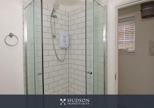 Un baño con ducha con puerta de cristal. en Detached House in Telford with Parking, en Telford