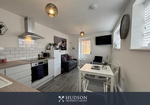 a kitchen and living room with a table and a kitchen and a dining room at Detached House in Telford with Parking in Telford