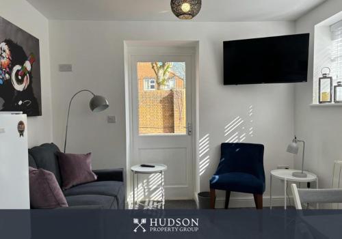 a living room with a couch and a tv on the wall at Detached House in Telford with Parking in Telford