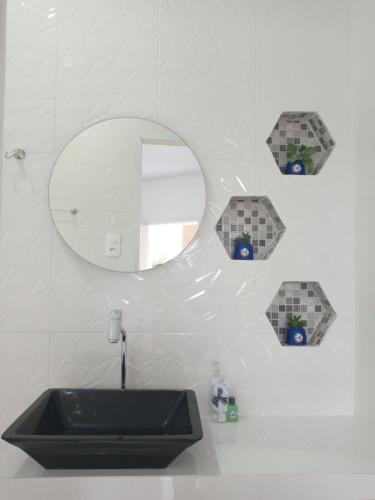 a bathroom with a sink and a mirror at Guará Apart 4 in Guaratuba