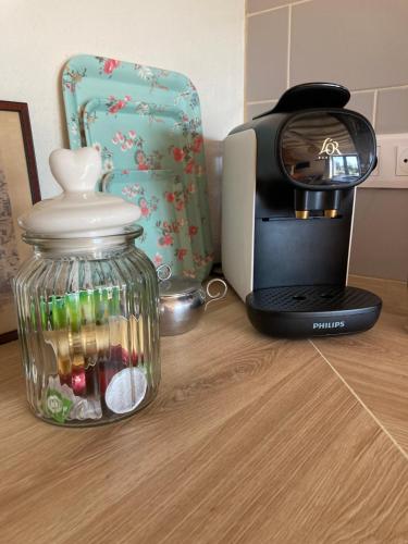 a coffee machine and a glass jar on a table at Gîte de charme et spa prés d'Albi , Au Mas de Bel Air in Arthès