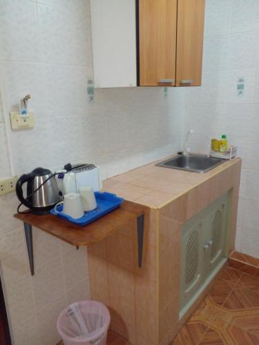 a kitchen with a sink and a counter top at Inn Lucky in Jomtien Beach