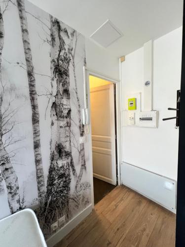 Cette chambre est ornée d'une fresque murale représentant des arbres. dans l'établissement Batignolles, Montmartre Chambre 12m2 , Metro 13 et 14, à Paris